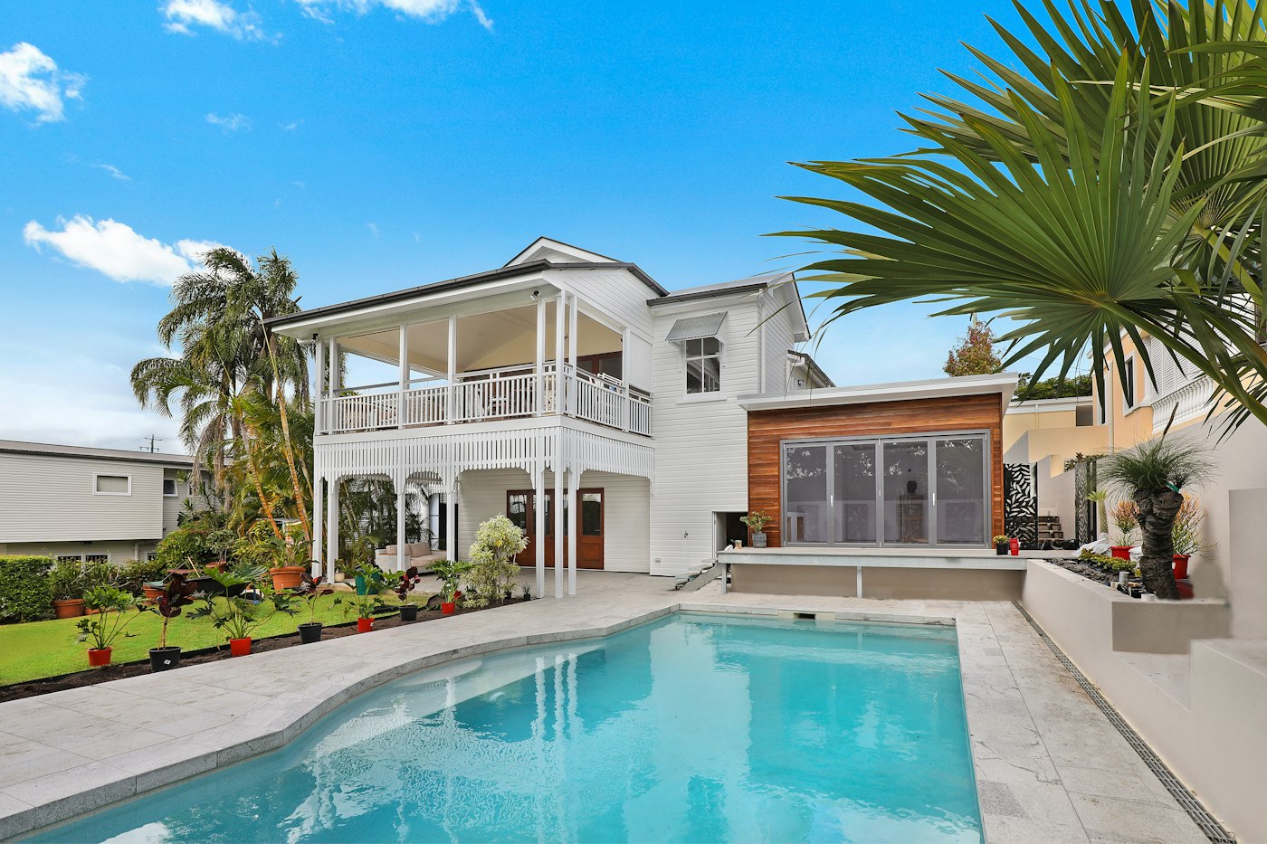 Sparkling residential pool with a white two-story house