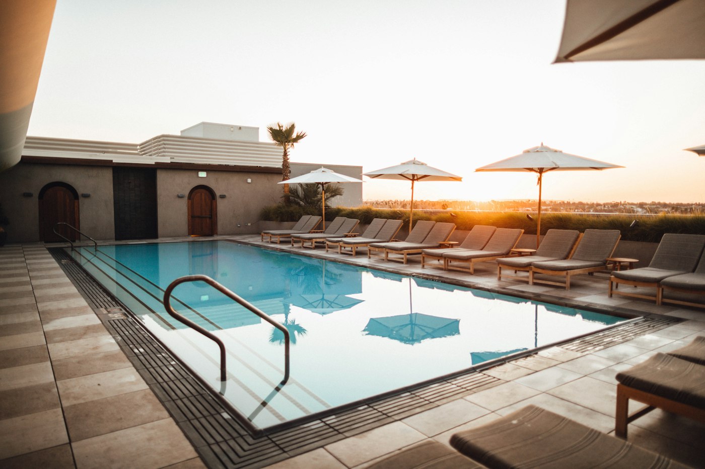 Clear pool and lounge chairs at sunset